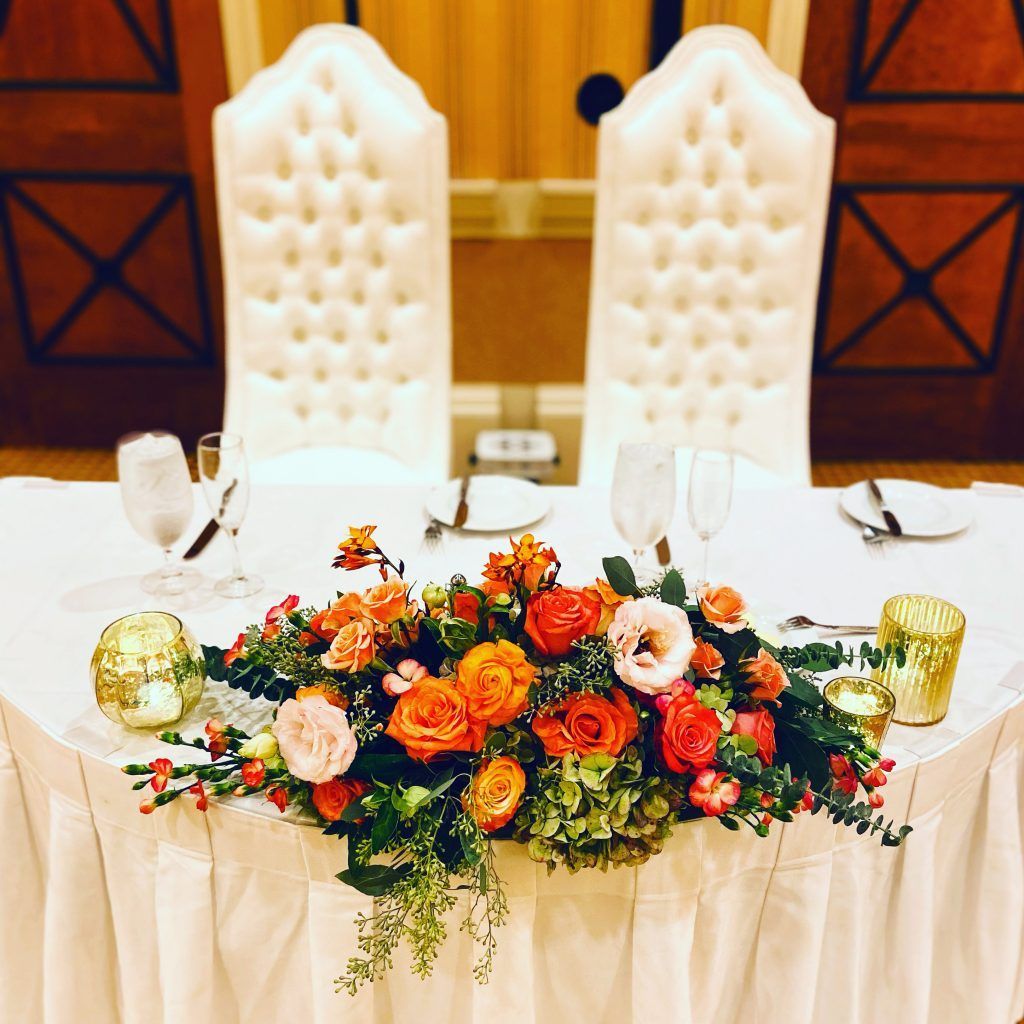 The bride and groom 's table is decorated with flowers and candles