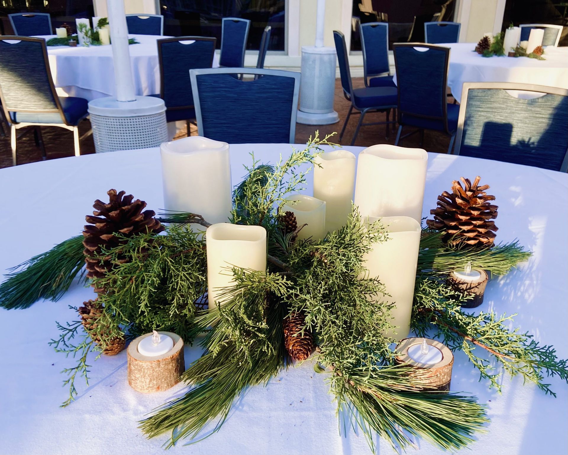 A table with candles and pine cones on it