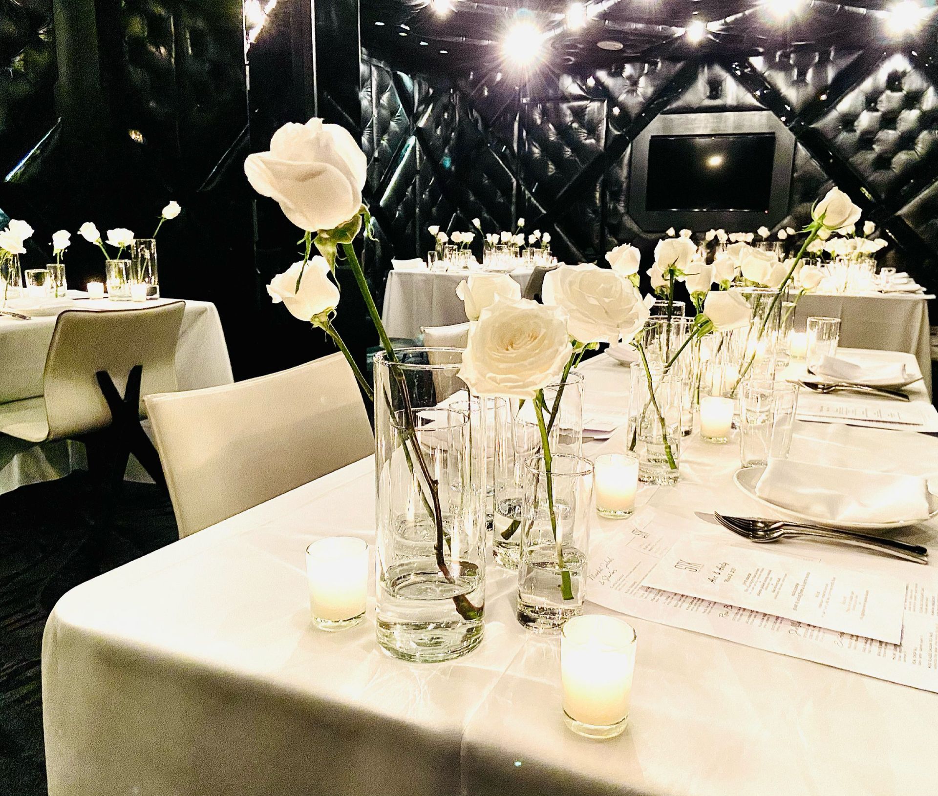 A table with white flowers and candles on it