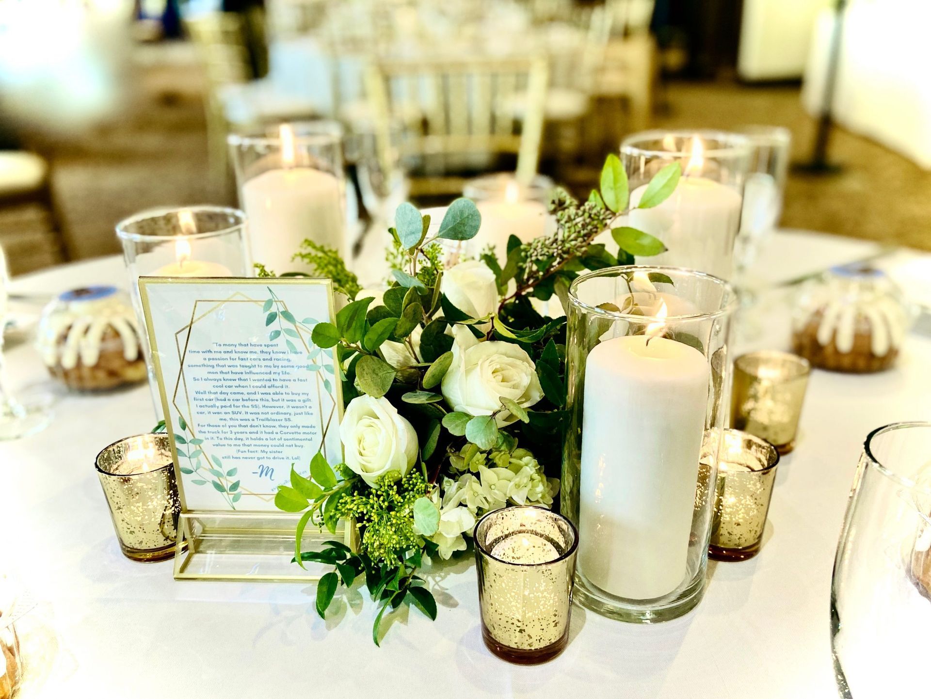 A table with a vase of flowers and candles on it.