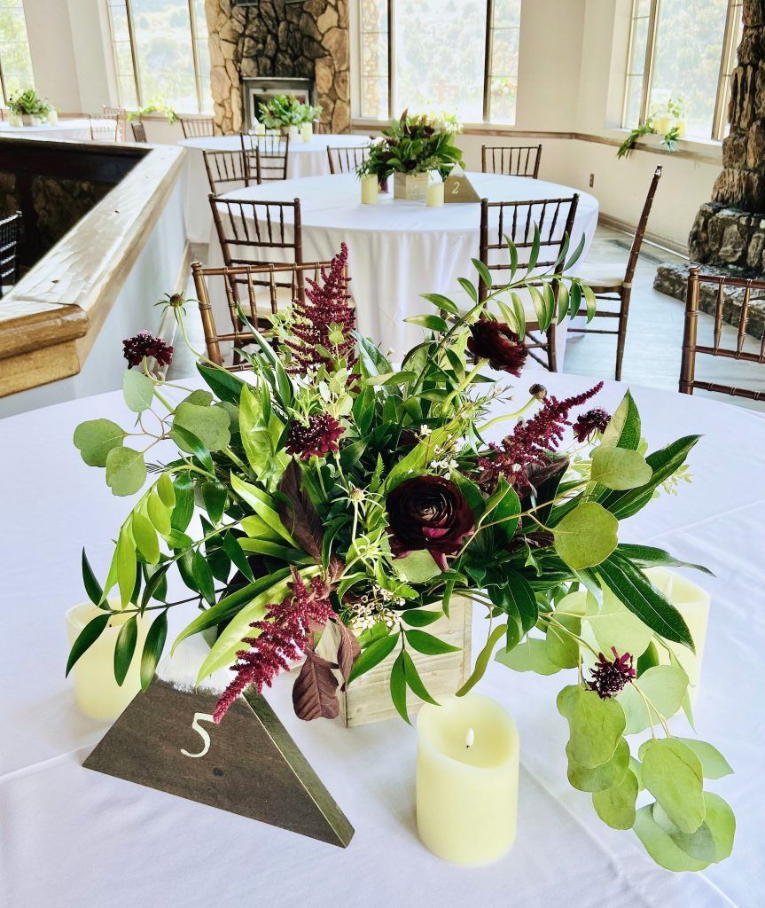 A table with a vase of flowers and candles on it