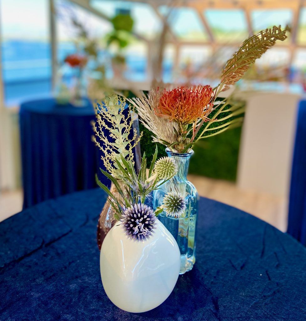 Two vases filled with flowers are sitting on a table.