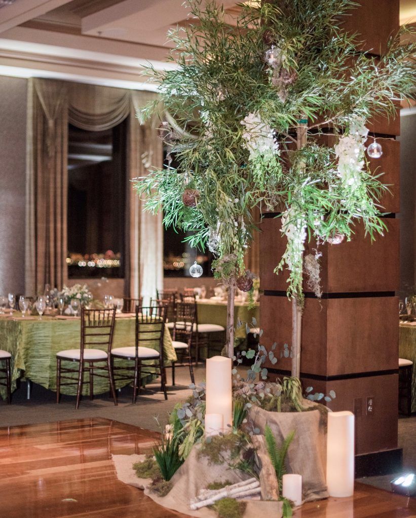 A room with tables and chairs and a tree in the middle.