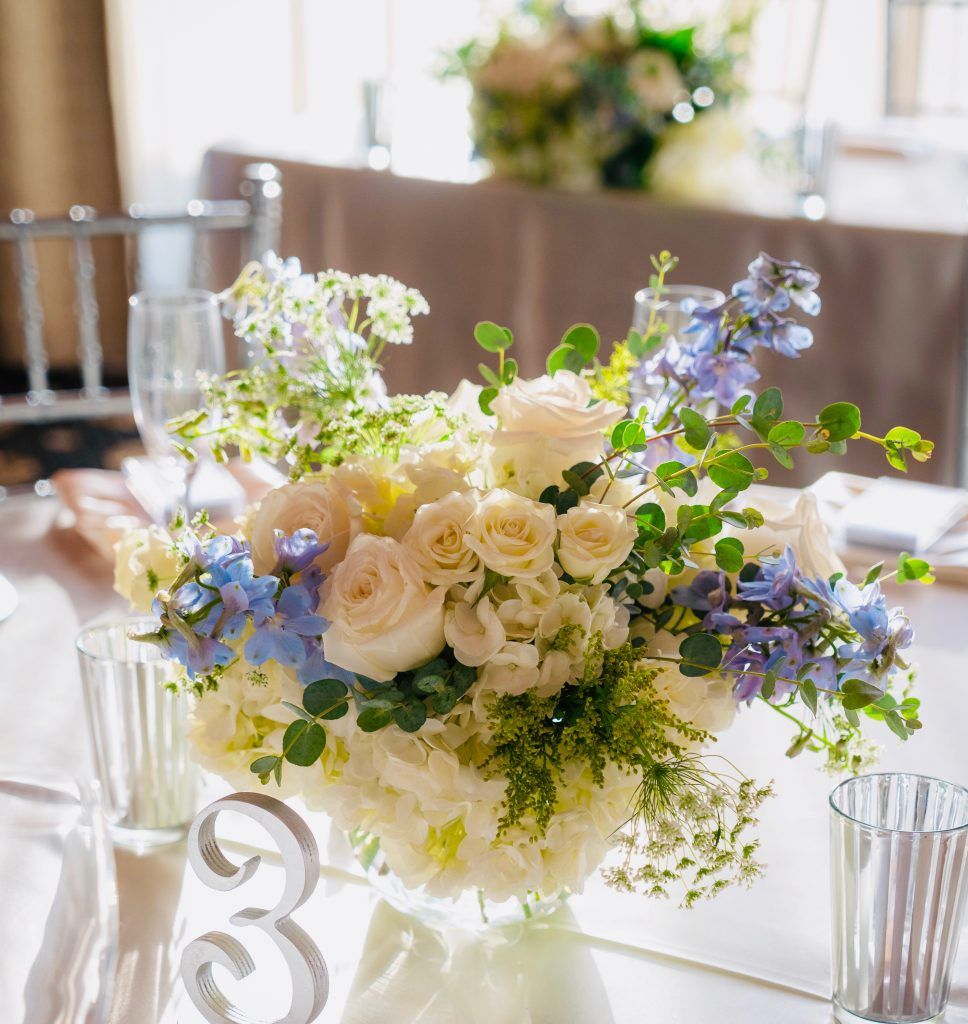 A vase of flowers sits on a table next to a number 33