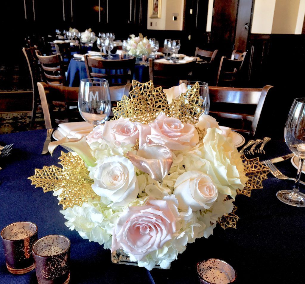 A table with a vase of flowers and candles on it