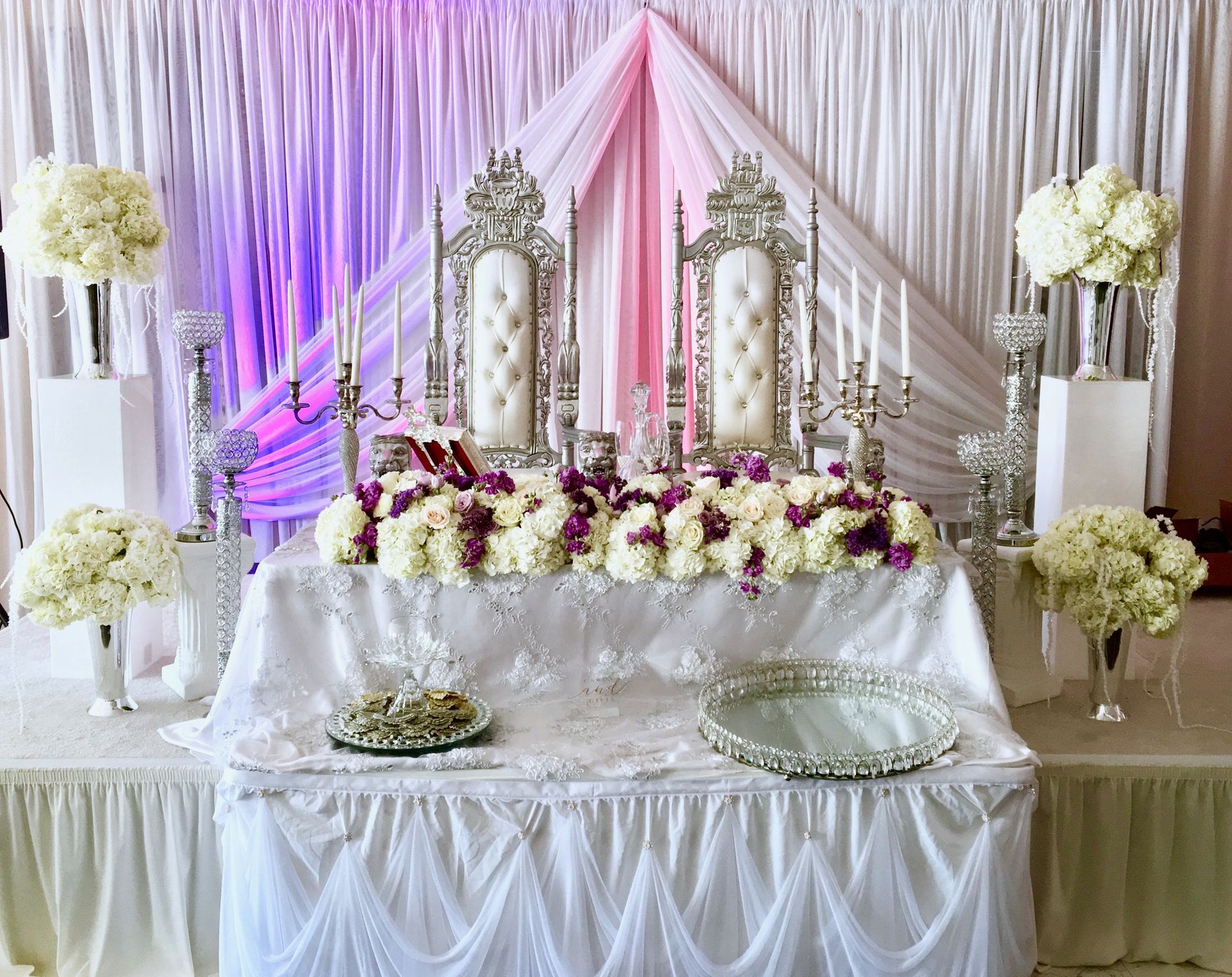 There is a table with flowers and candles on it.