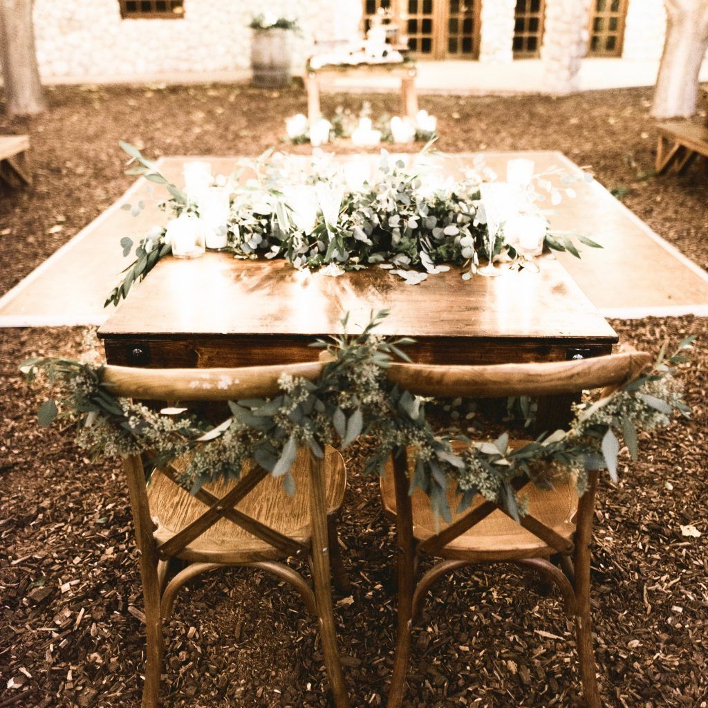 A couple of chairs sitting next to a table with flowers on it.