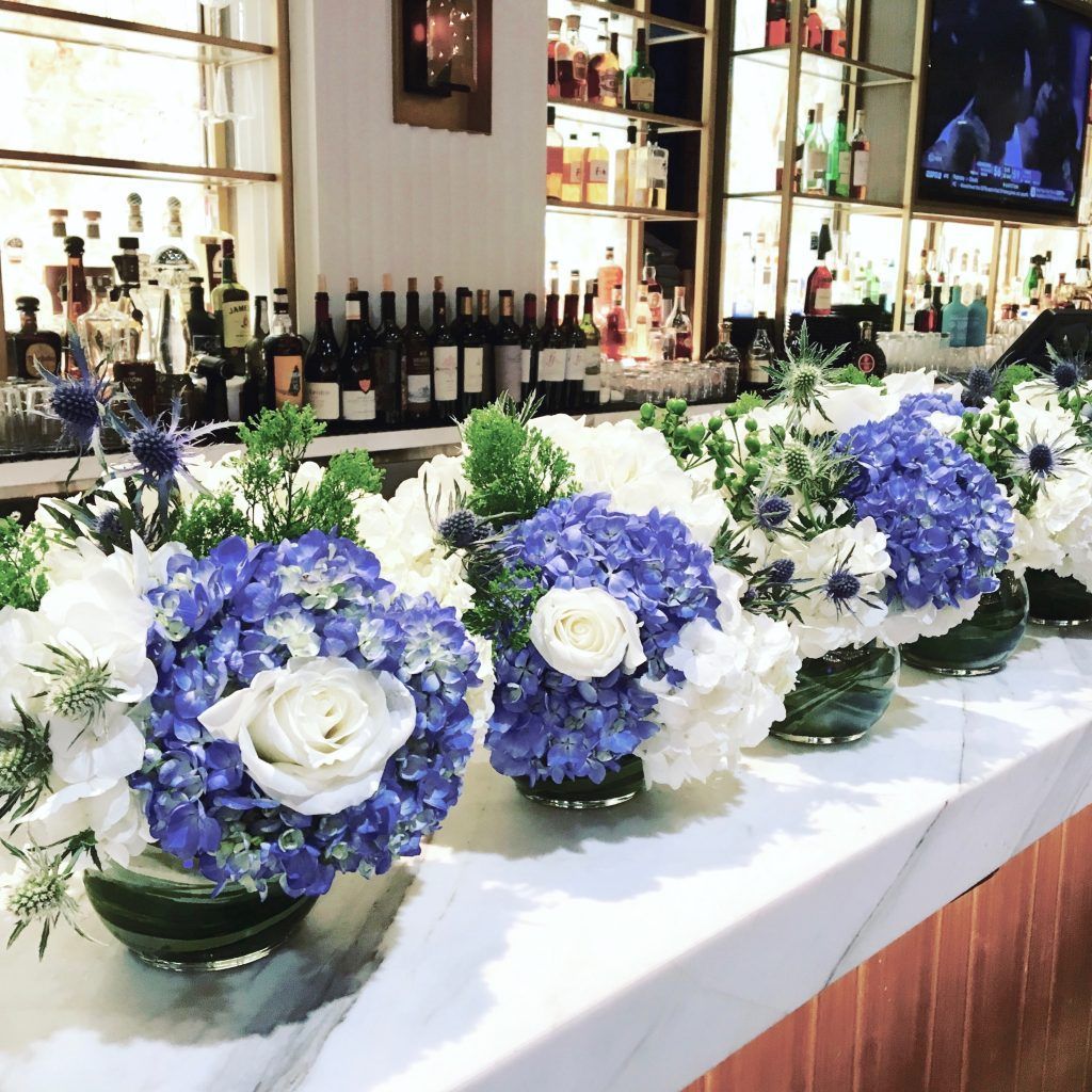 A row of vases filled with blue and white flowers