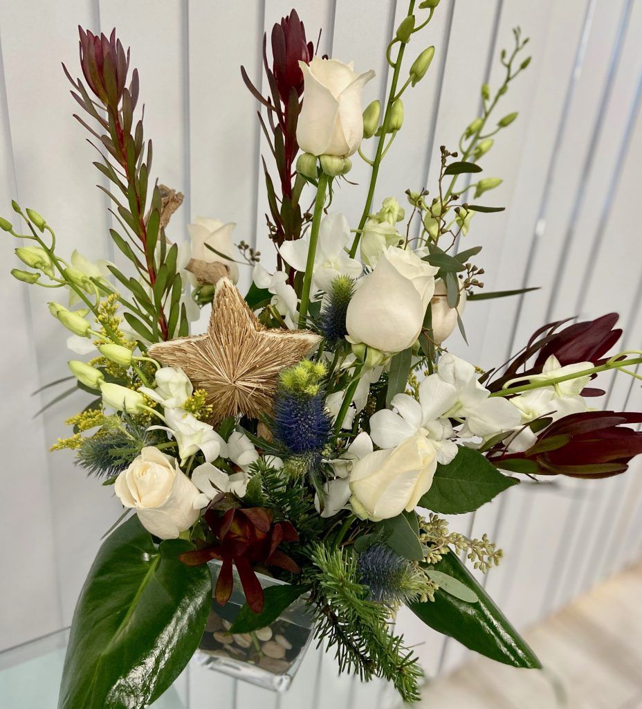 A vase filled with flowers with a starfish in the middle