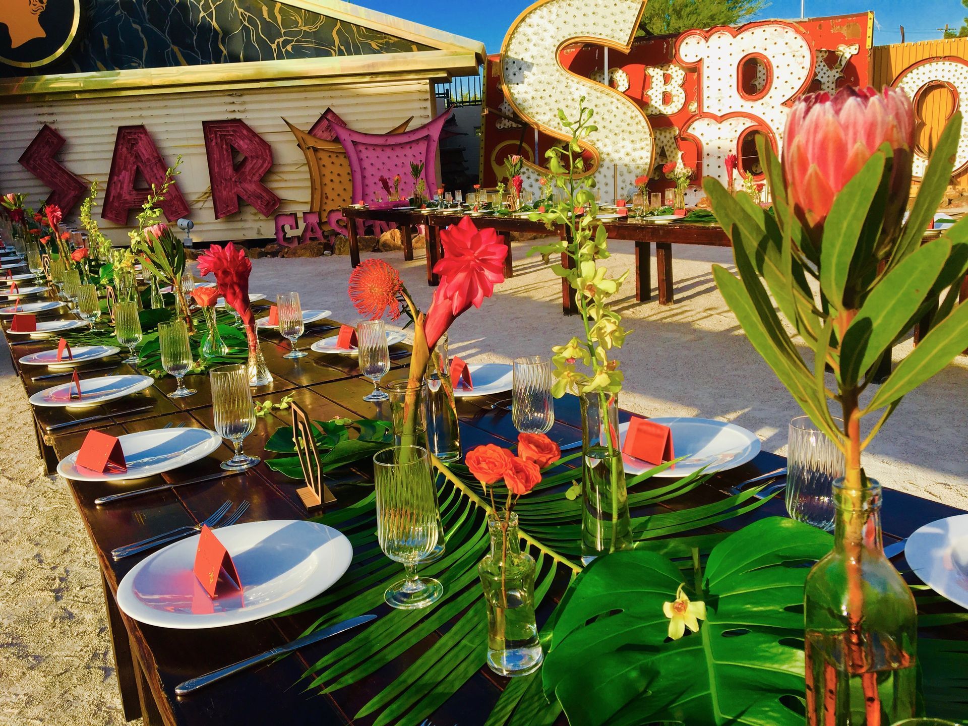 A long table with plates , glasses and flowers on it