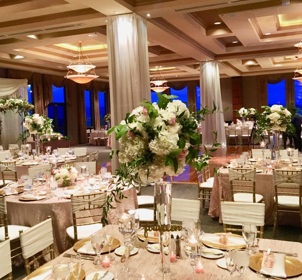 A large room with tables and chairs set up for a wedding reception.