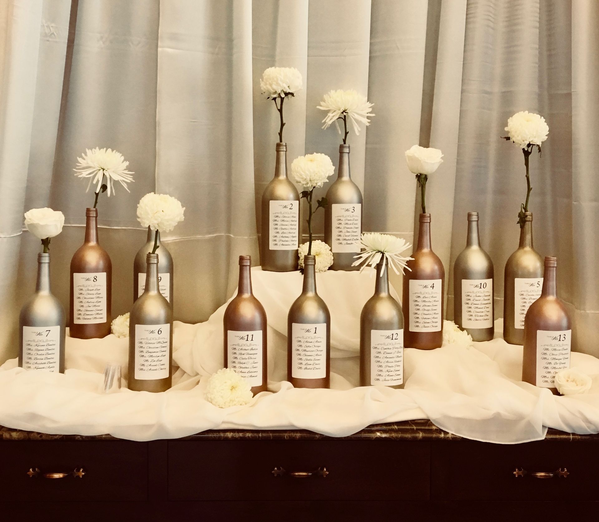 A display of wine bottles with flowers in them