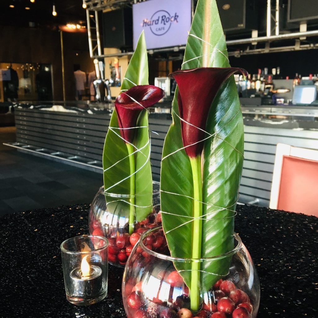 A hard rock sign is behind two vases of flowers