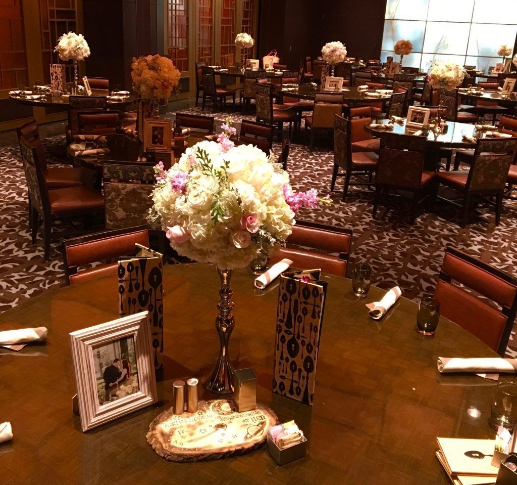 A table with a vase of flowers and a picture frame on it