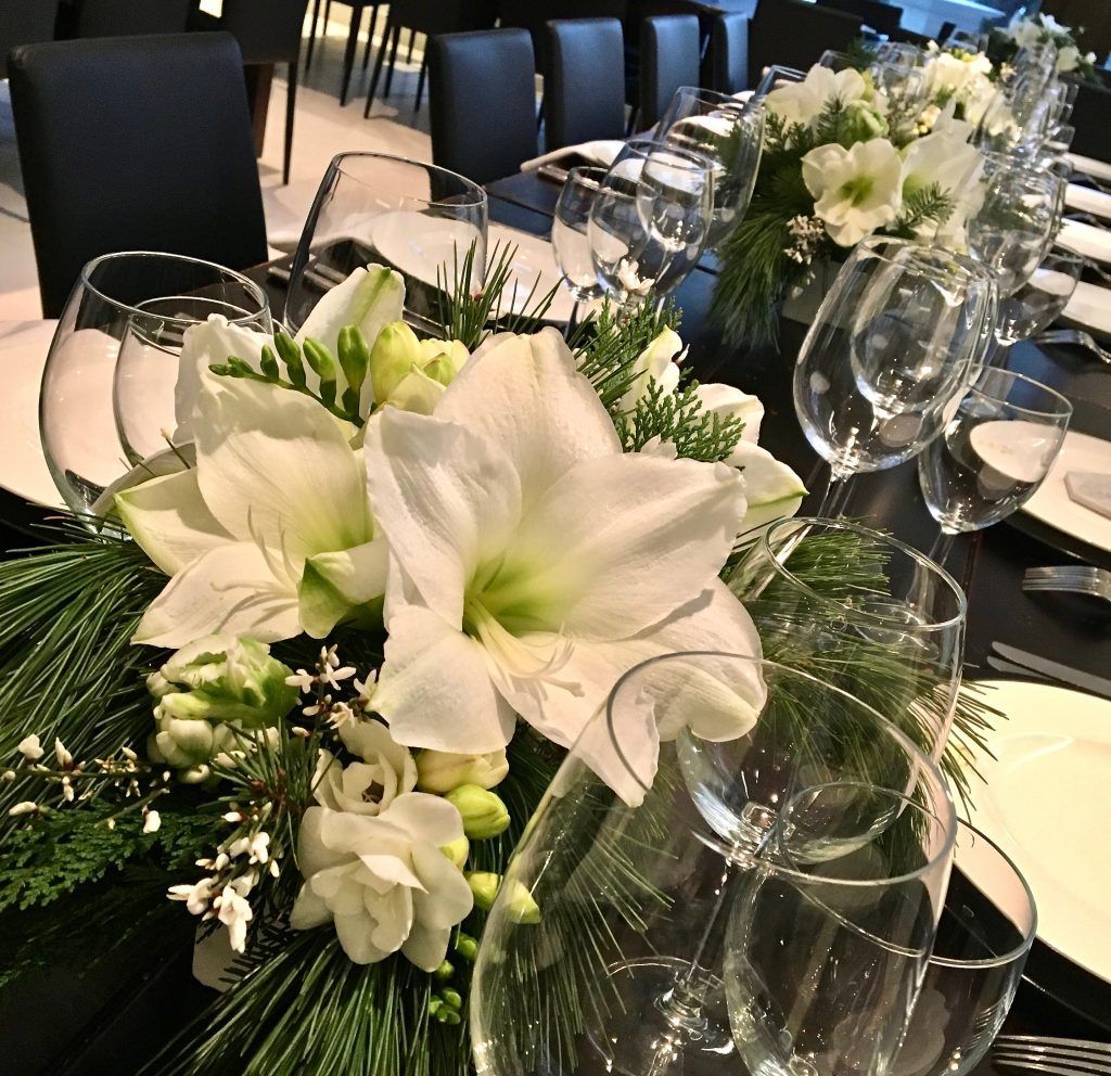 A long table with flowers and wine glasses on it