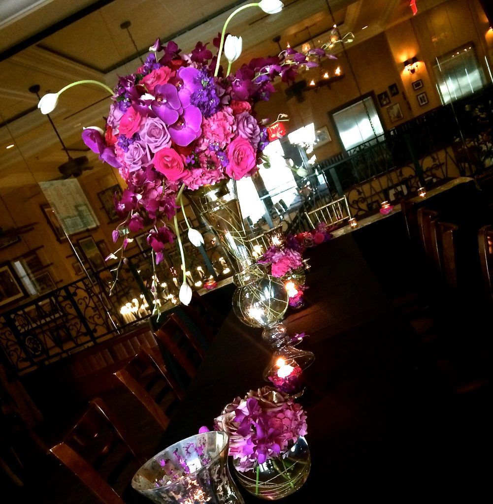 A vase filled with purple flowers sits on a table