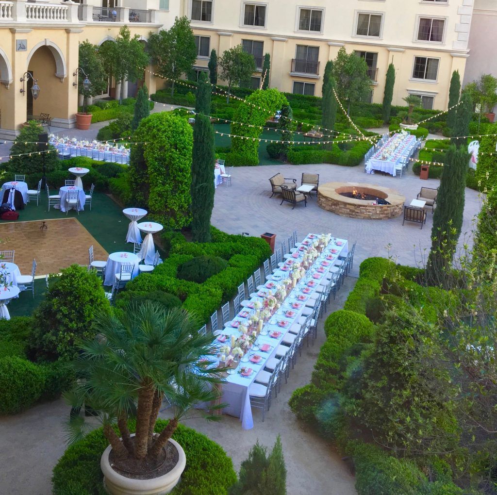 An aerial view of a garden with tables and chairs and a fire pit