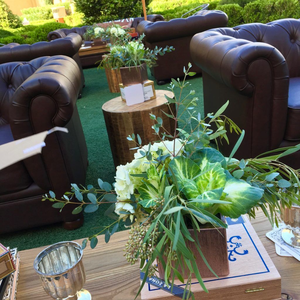 A table with a vase of flowers on it in front of a couch.