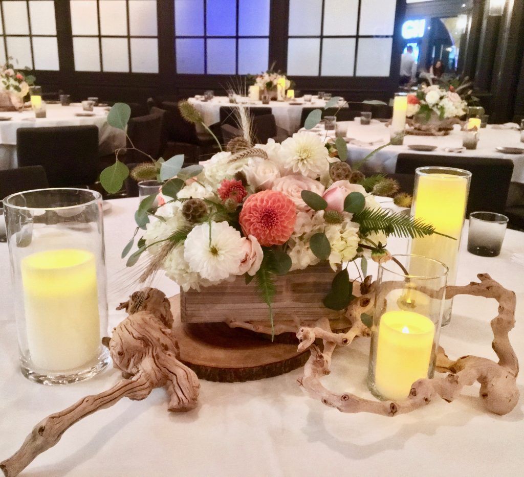 A table with a vase of flowers and candles on it