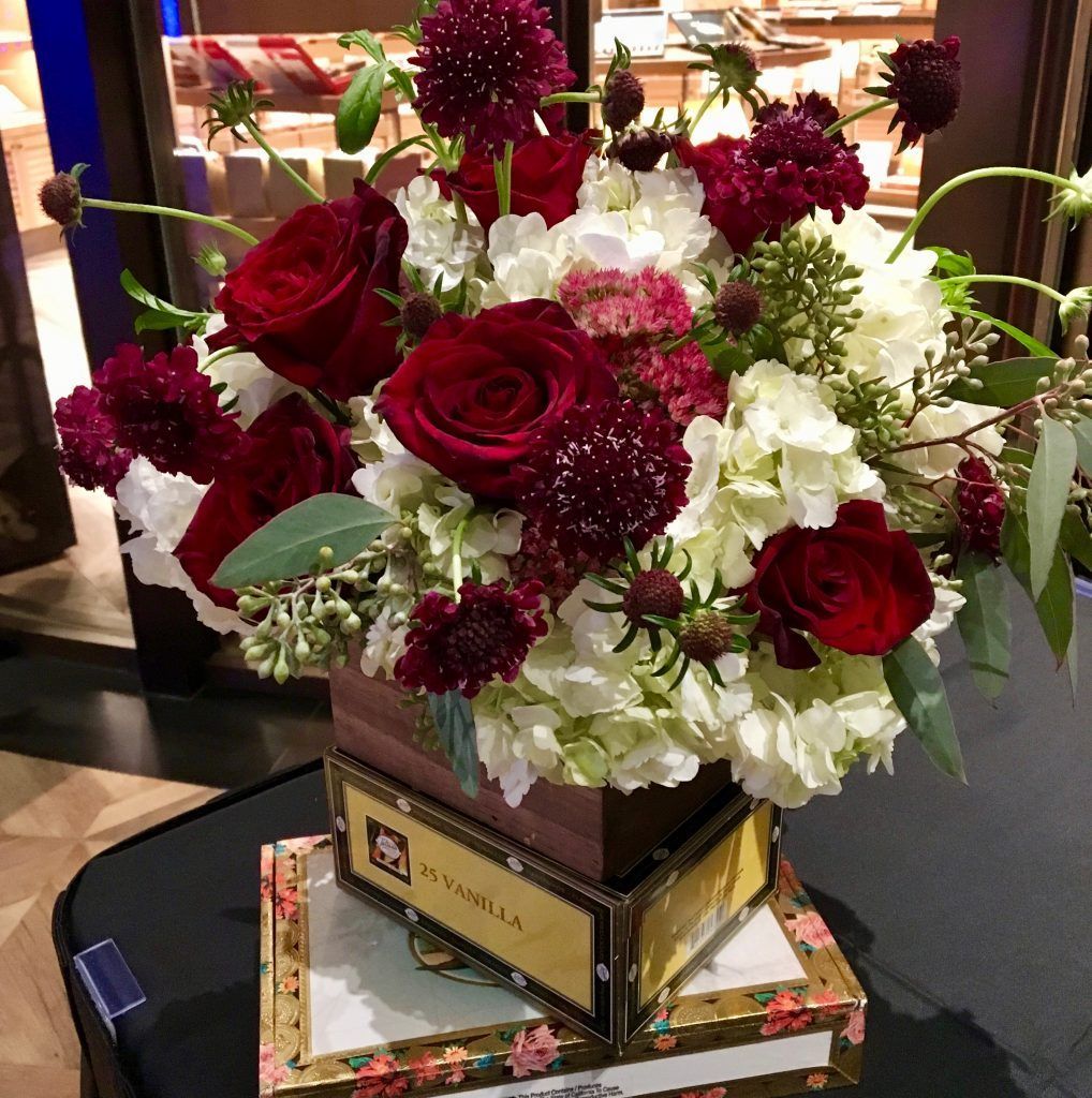 A vase filled with red roses and white flowers