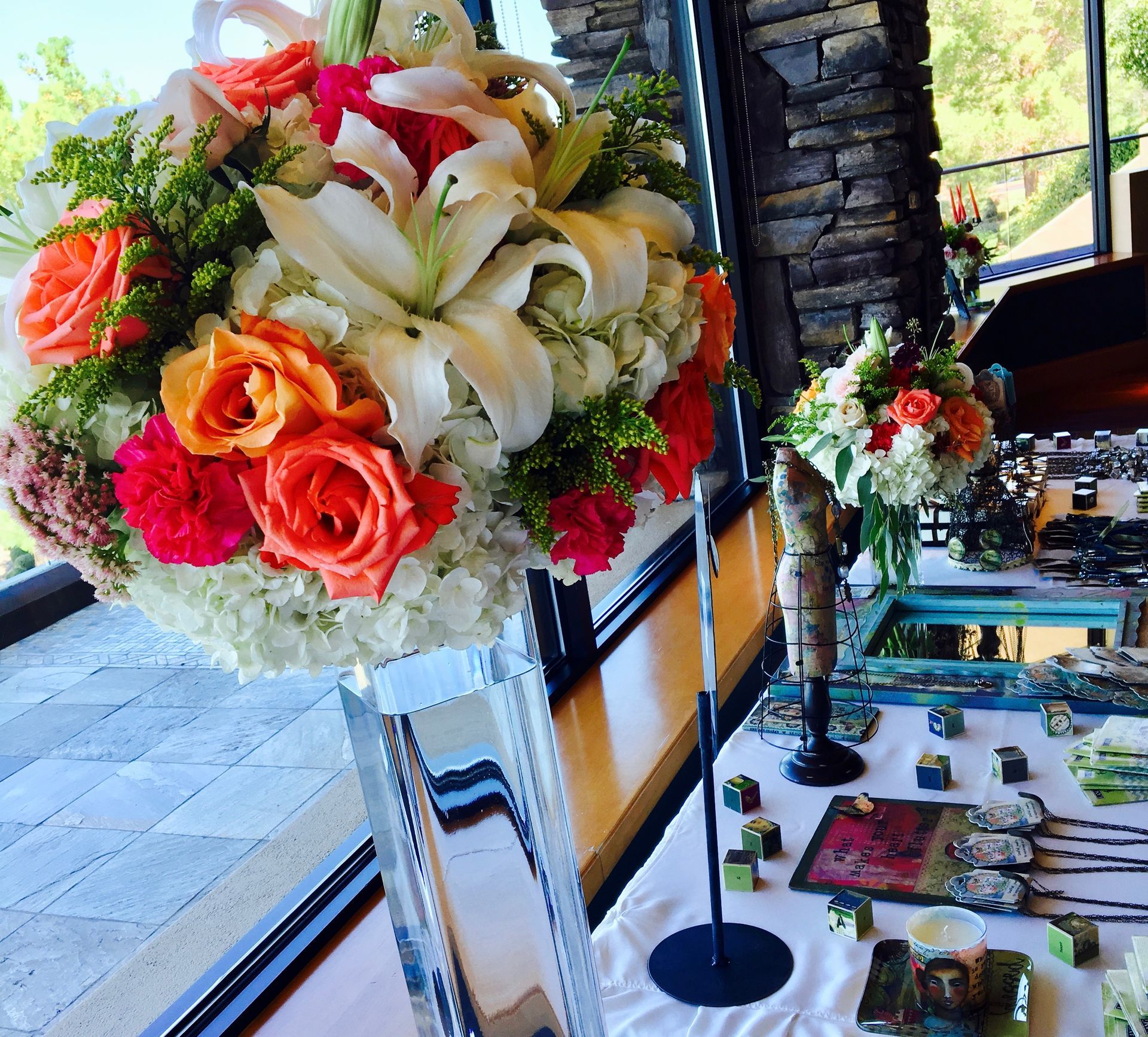 A vase filled with flowers sits on a table in front of a window