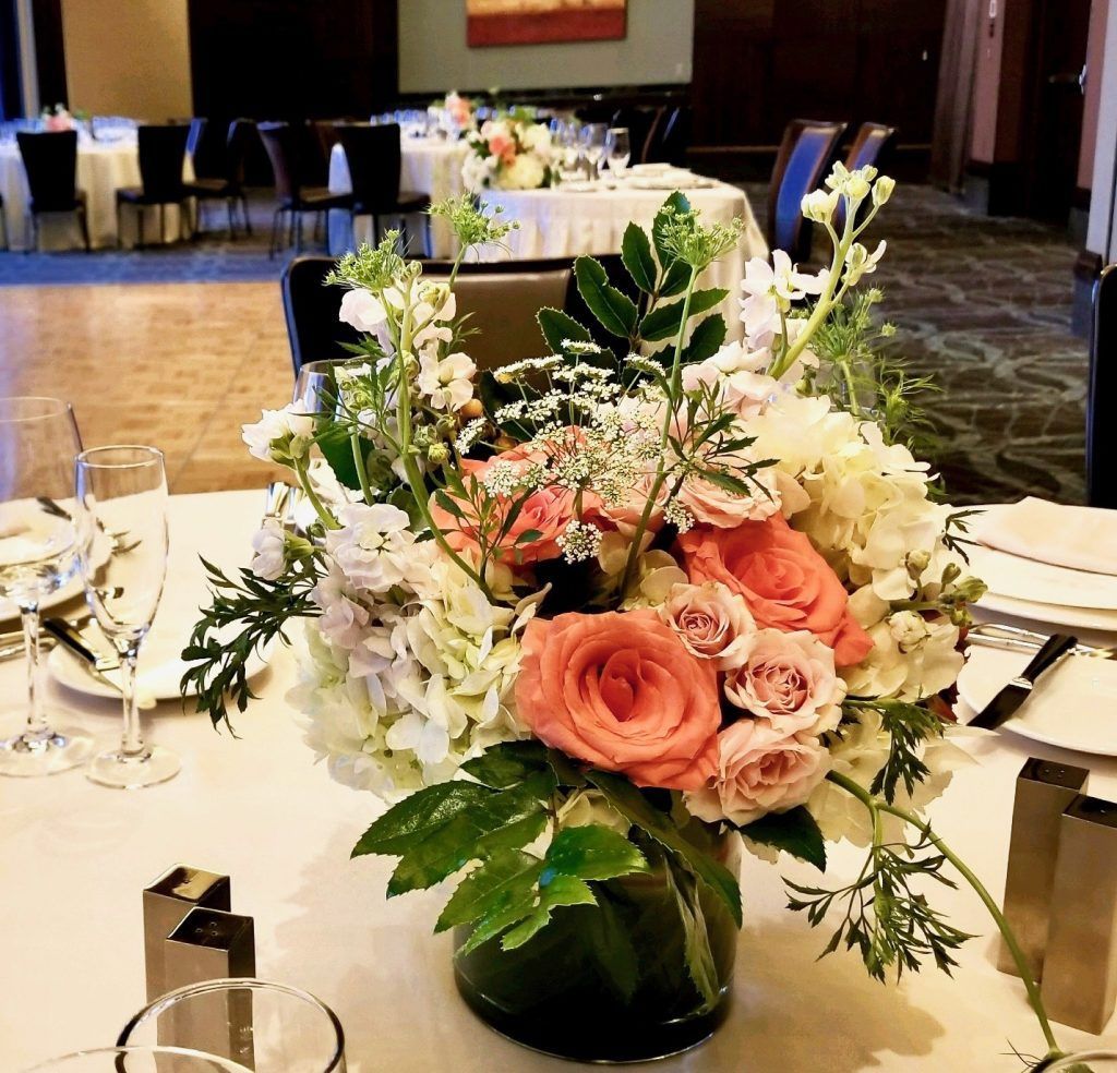 A vase filled with flowers sits on a table
