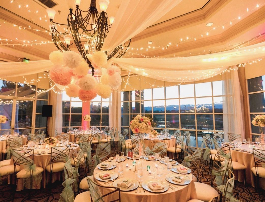 A large room with tables and chairs set up for a wedding reception.