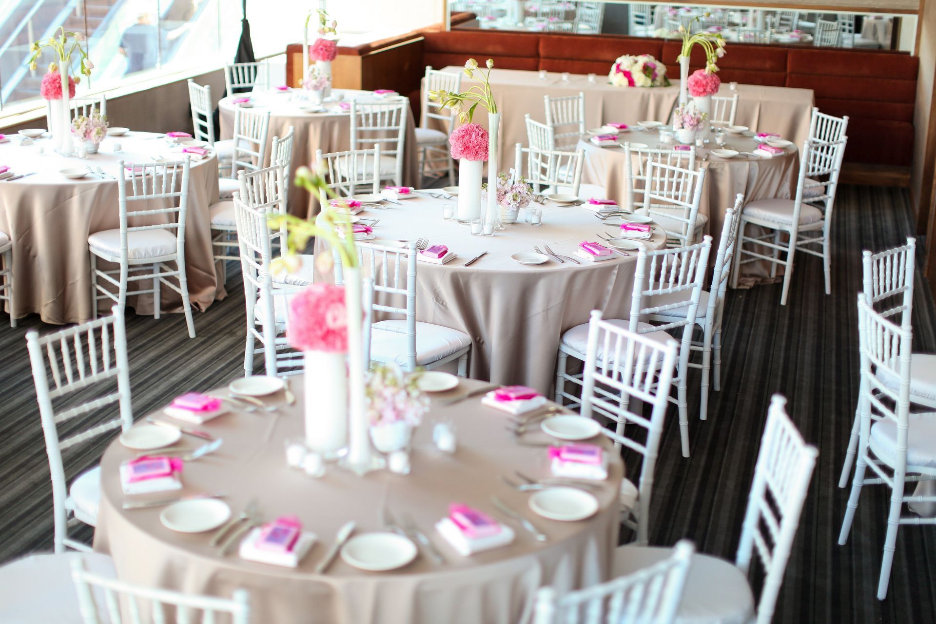 A room with tables and chairs set up for a wedding reception