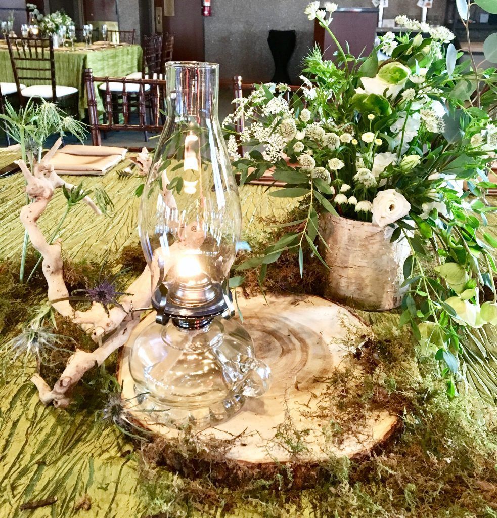 A table with a lantern and flowers on it.