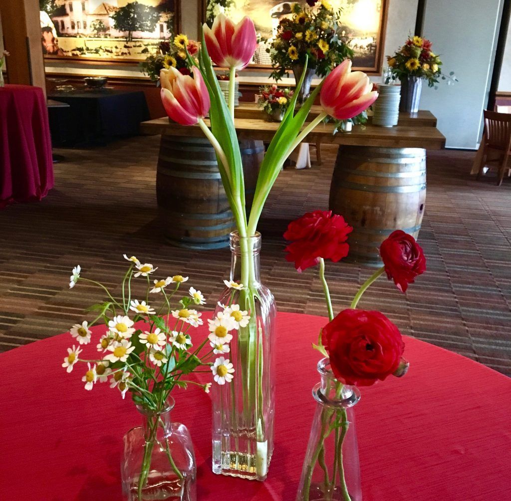 A table with three vases filled with flowers on it
