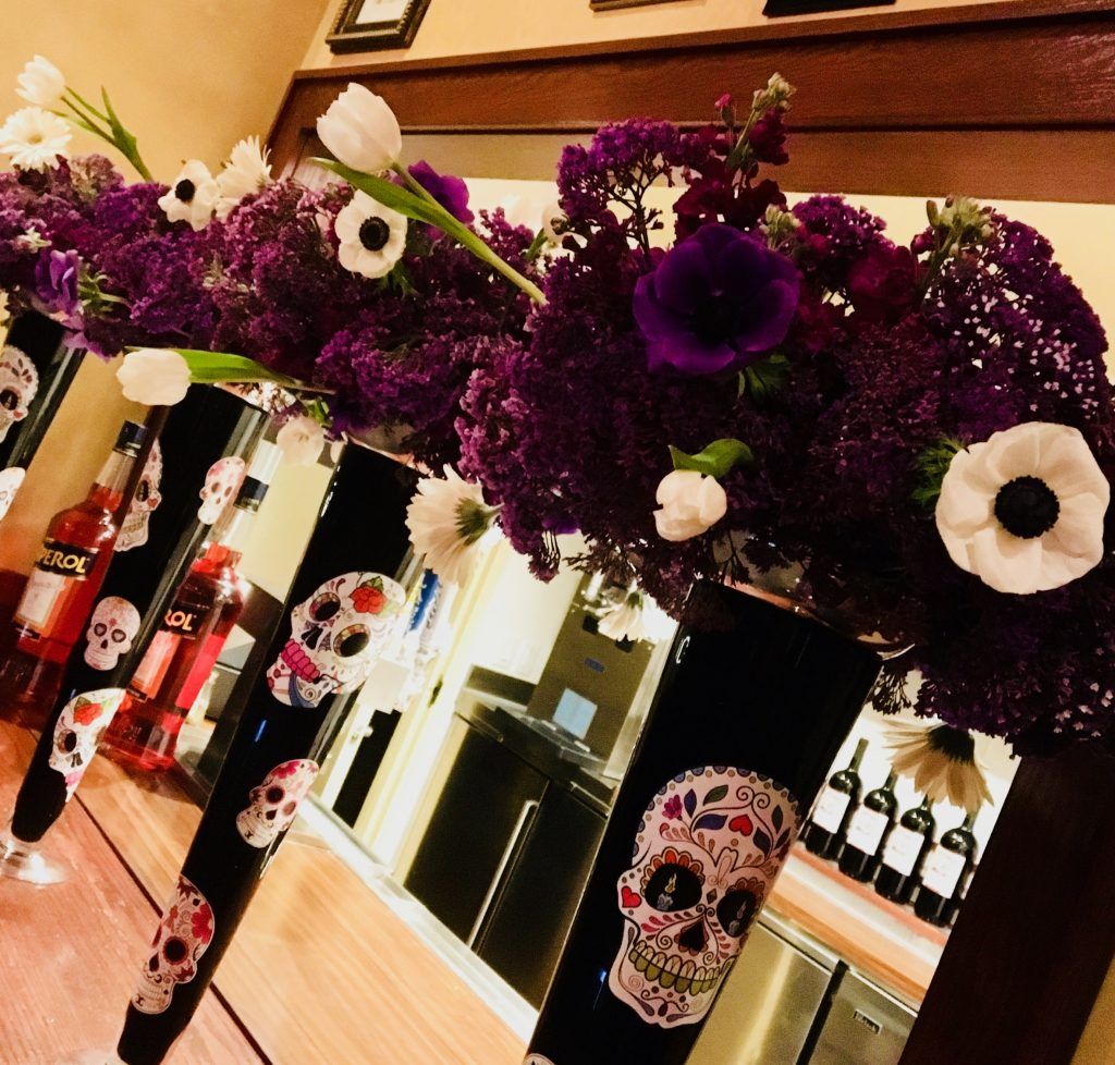 A display of purple flowers and sugar skulls