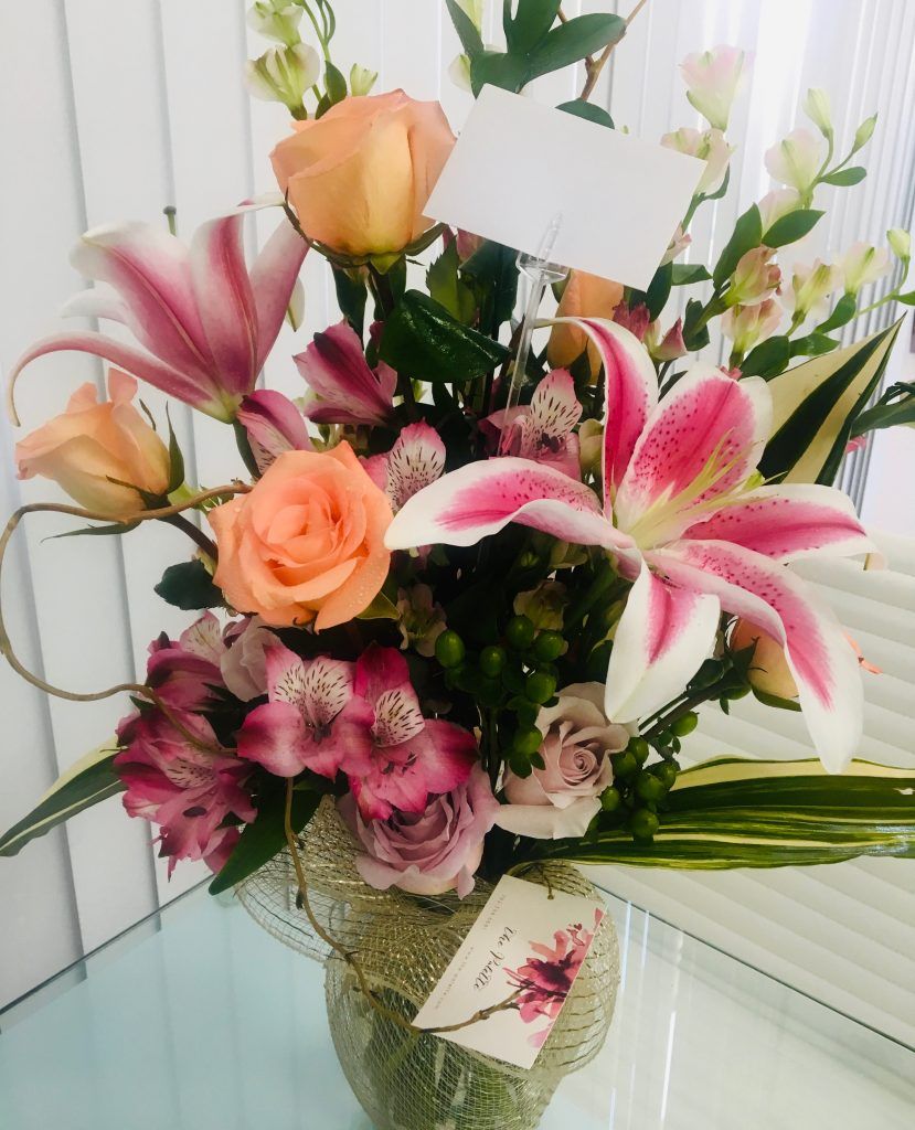 A vase filled with flowers and a card on a table
