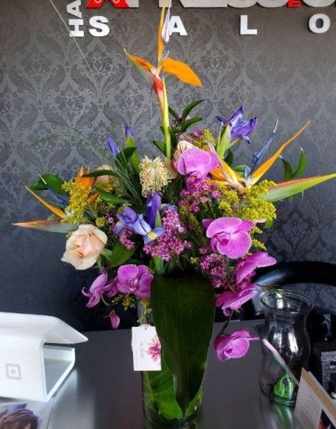A vase filled with purple flowers sits on a table