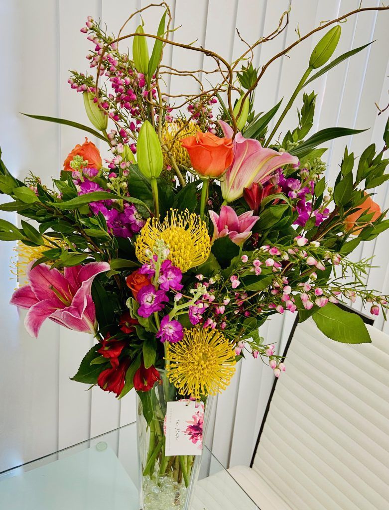 A vase filled with colorful flowers is sitting on a table.