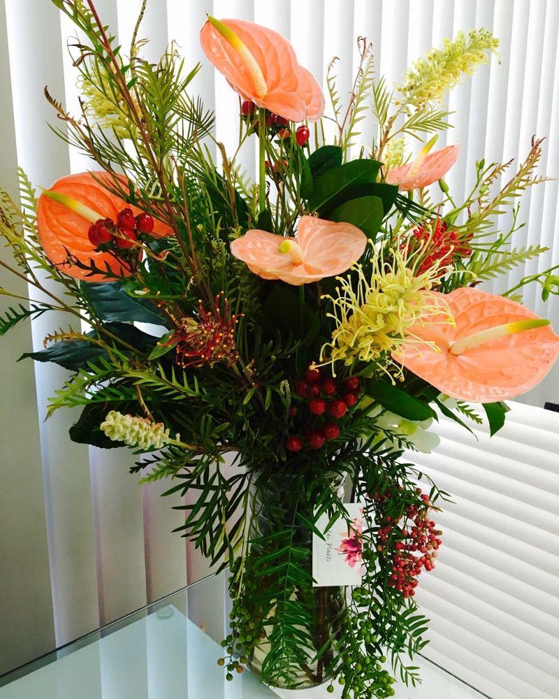 A vase filled with flowers and leaves on a table