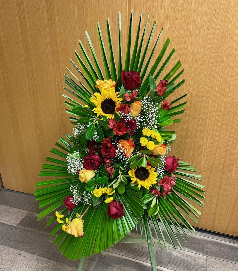 A bouquet of flowers is sitting on a table in front of a wooden wall.