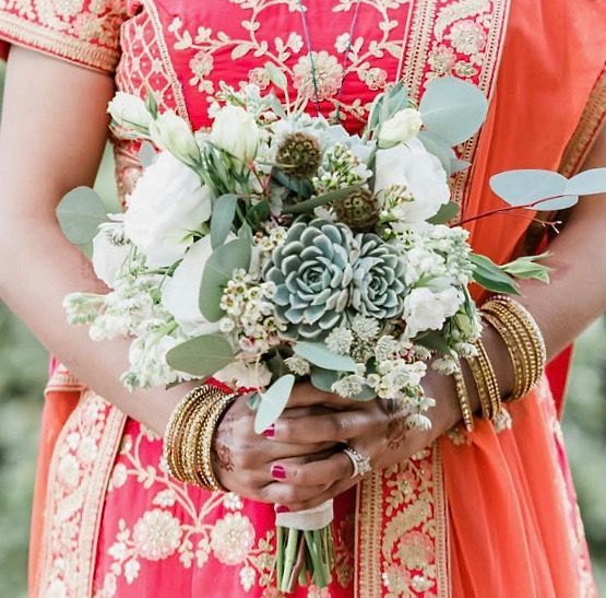 A woman in a red dress is holding a bouquet of flowers