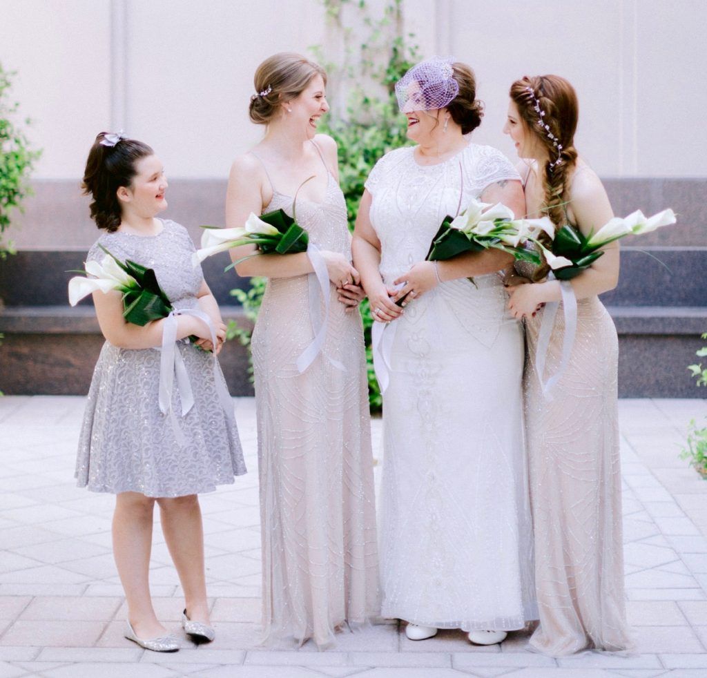 A bride and her bridesmaids are posing for a picture