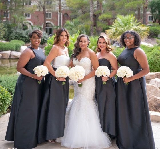 A bride and her bridesmaids are posing for a picture
