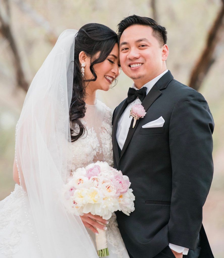 A bride and groom are posing for a picture on their wedding day.