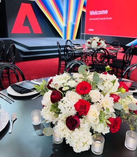 A table with flowers and candles in front of a welcome sign