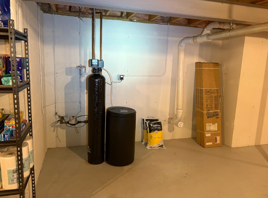 A person holding a baby up in the air indoors near a window, baby smiling.