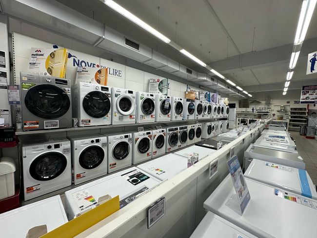 Una fila di lavatrici sono allineate in un negozio.