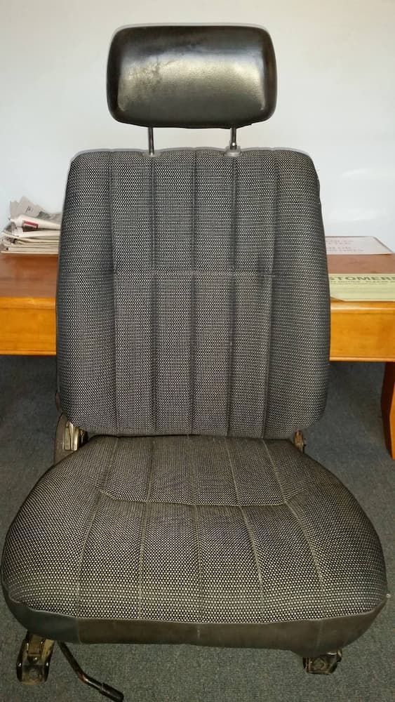 A Chair With A Headrest Is Sitting In Front Of A Wooden Table — Simmons Glass & Trim In Oberon, NSW