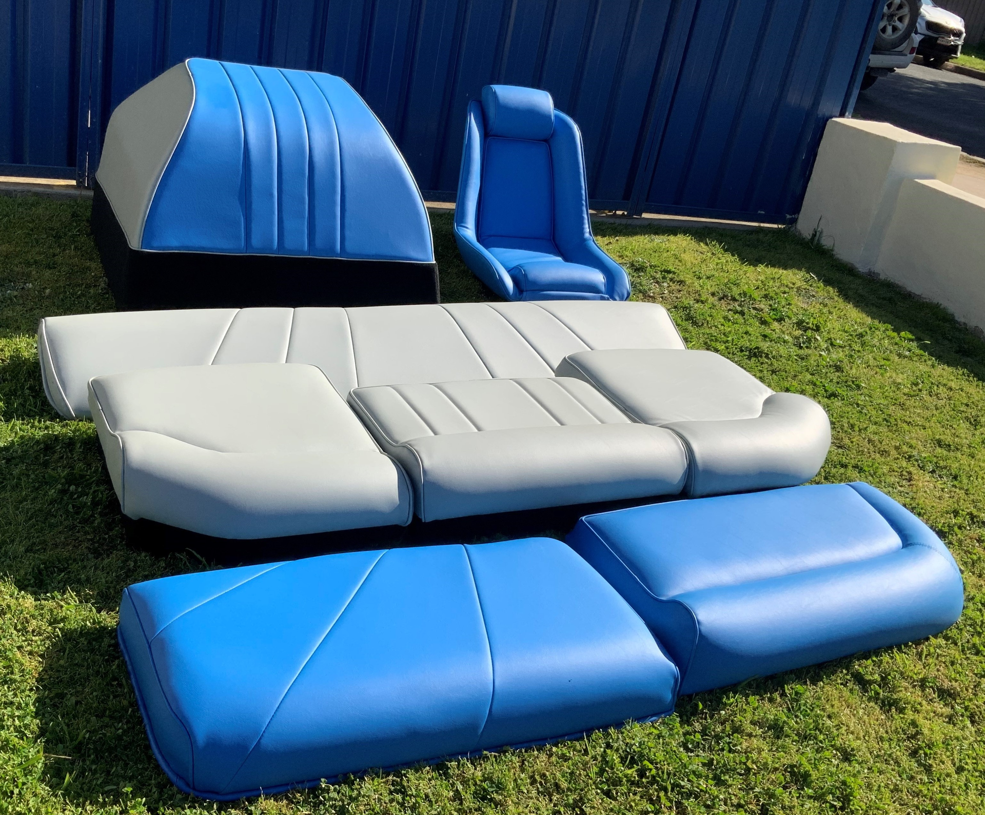 Blue And Grey Seat Covers Laying On Grass — Simmons Glass & Trim In Bathurst, NSW