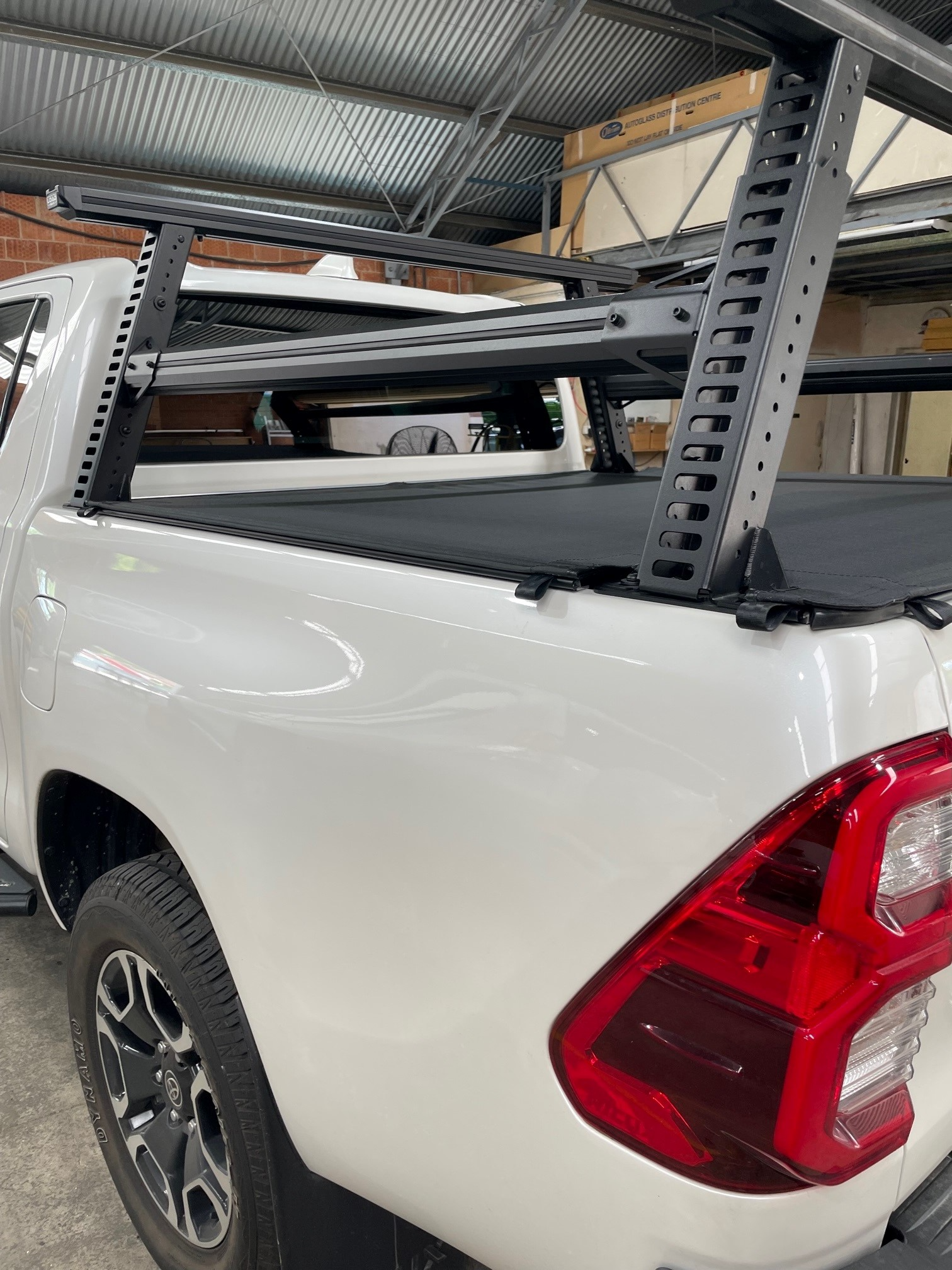 A White Ute Is Parked In A Garage With A Canopy Cover — Simmons Glass & Trim In Bathurst, NSW