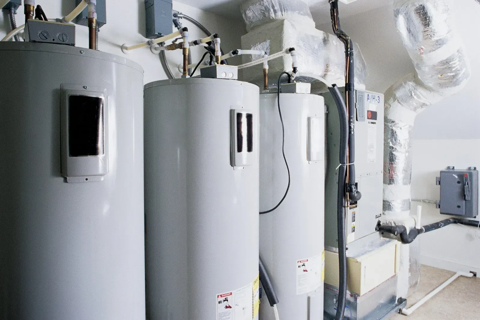 A row of water heaters are lined up in a room.