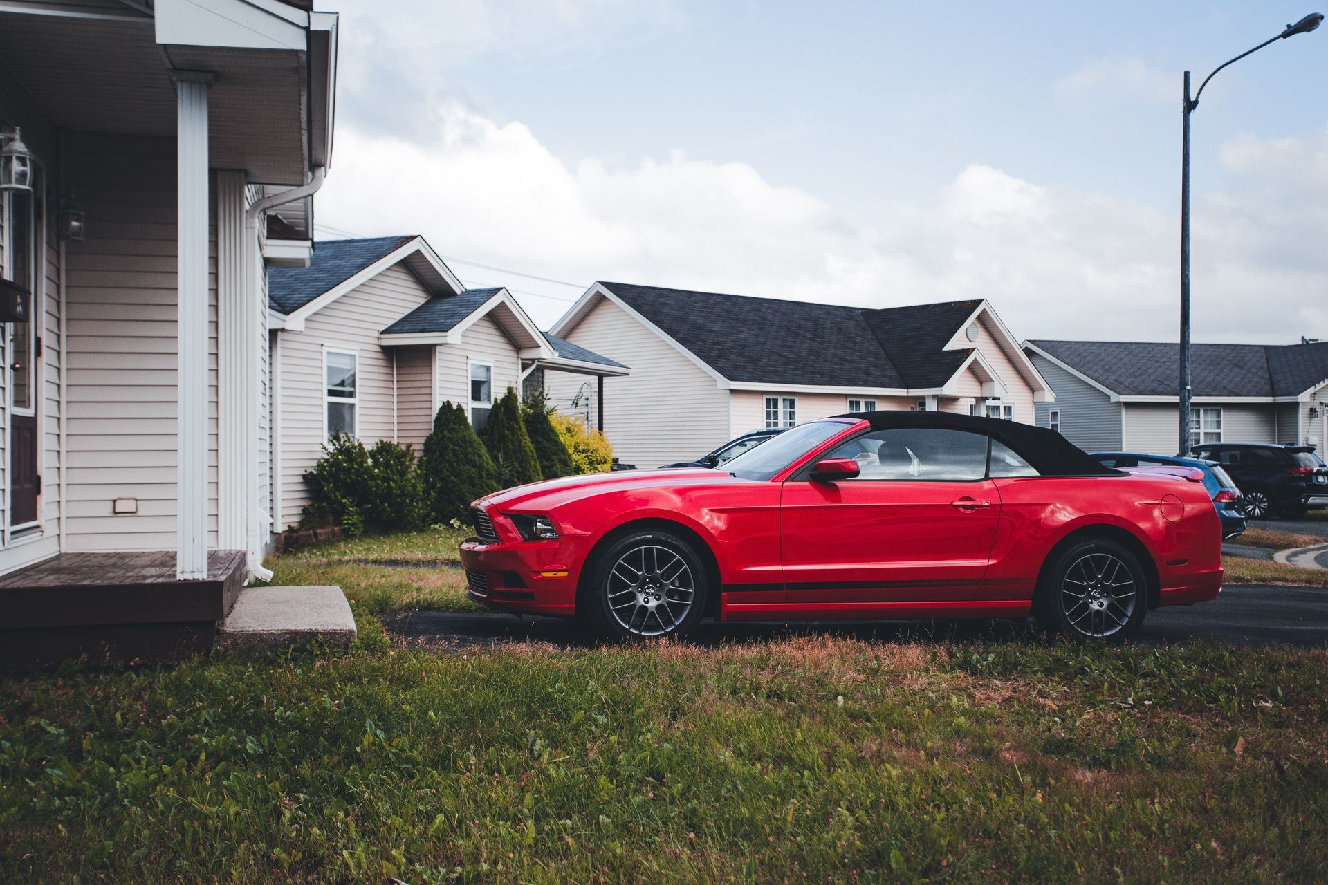 Red car parked in the driveway of a suburban Arizona home after its owner started driving less