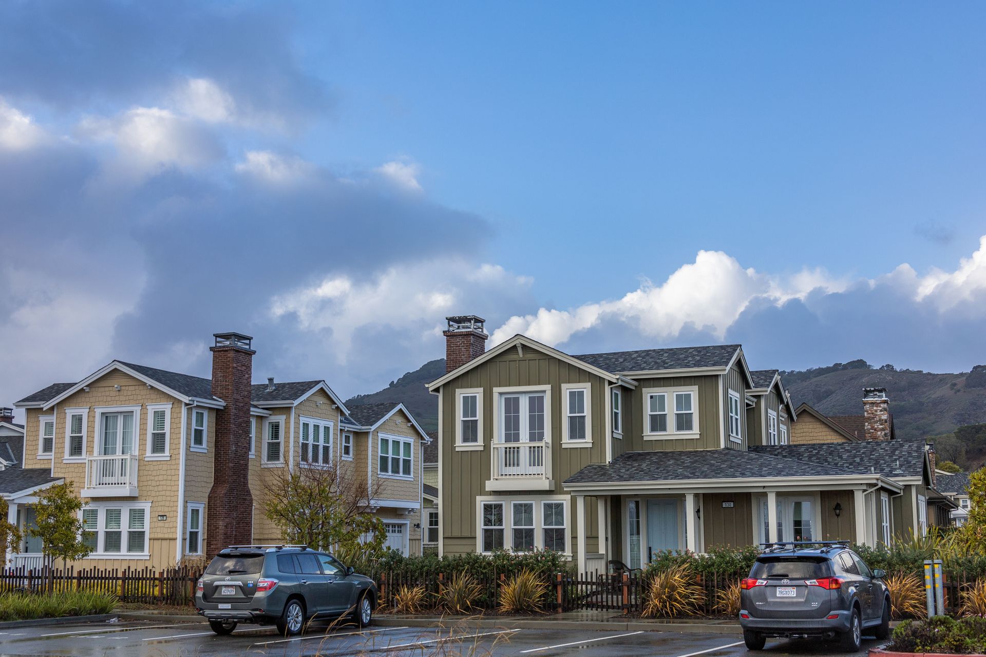 Suburban Arizona neighborhood homes with cars parked out front under a blue sky