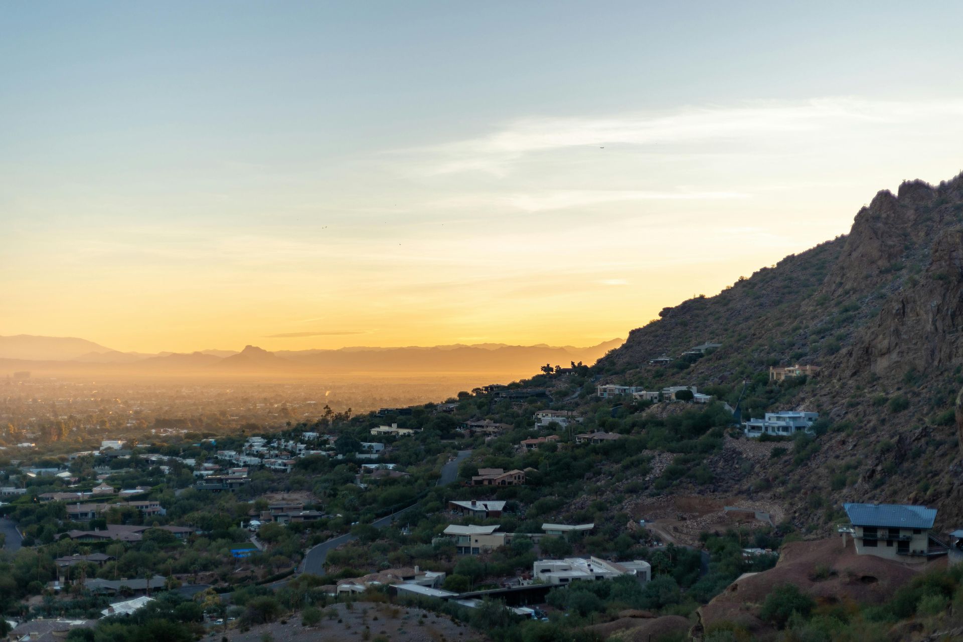 Phoenix, Arizona neighborhood at sunset with Camelback Mountain corridor and homes against the hillside